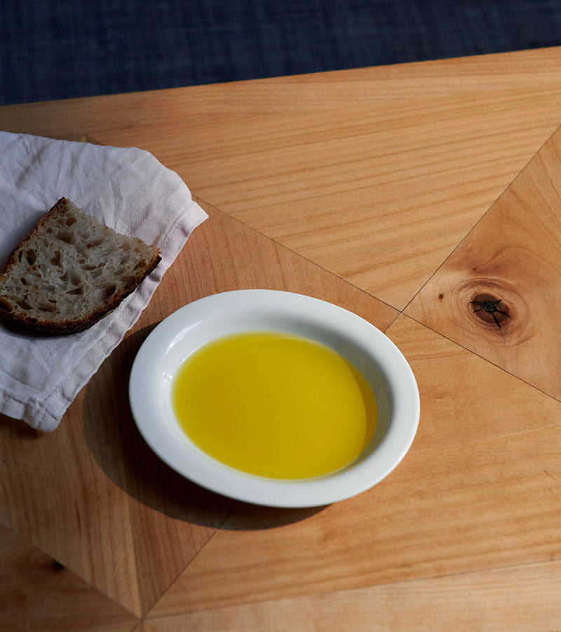 Japanske porselen oval tallerken fra Arita 1616 / Japan. Design: Cecilie Manz. Kan kjøpes ved Kollekted by en interiørbutikk på Grünerløkka, Oslo. Stemningsbilde brød og olivenolje fra The Table Project