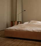 The Floating Bed av den svenske møbelsnekkeren Axel Wannberg er en minimalistisk seng laget av massiv svensk furu, som svever over gulvet for å skape en lett og rolig atmosfære. Bildet viser Teklla Bedding Winter White og Lumina Daphne gulvlampe hos Kråkvik & D´Orazio. Fåes ved Kollekted by som er en interiørforretning på Grünerløkka i Oslo.
