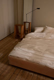 The Floating Bed av den svenske møbelsnekkeren Axel Wannberg er en minimalistisk seng laget av massiv svensk furu, som svever over gulvet for å skape en lett og rolig atmosfære. Bildet viser Teklla Bedding White og Lumina Daphine gulvlampe, bukker fra Audo hos Kråkvik & D´Orazio. Fåes ved Kollekted by som er en interiørforretning på Grünerløkka i Oslo.