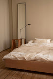 The Floating Bed av den svenske møbelsnekkeren Axel Wannberg er en minimalistisk seng laget av massiv svensk furu, som svever over gulvet for å skape en lett og rolig atmosfære. Bildet viser Teklla Bedding White og Lumina Daphine gulvlampe og Audo bukker hos Kråkvik & D´Orazio. Fåes ved Kollekted by som er en interiørforretning på Grünerløkka i Oslo.
